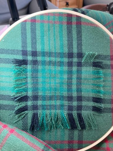 Kilt Mending In Progress Invisible mending in progress on moth - damaged tartan